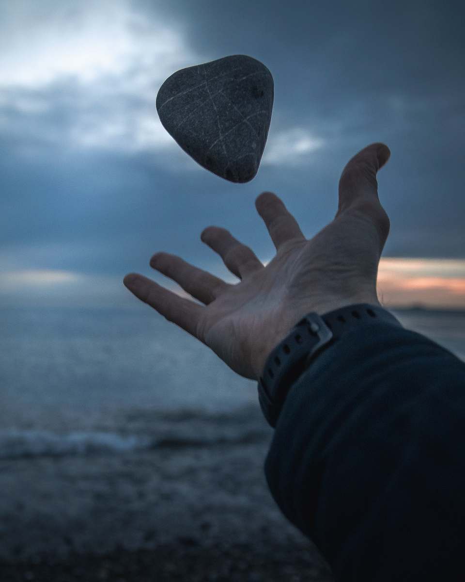 person person's hand throwing gray stone human