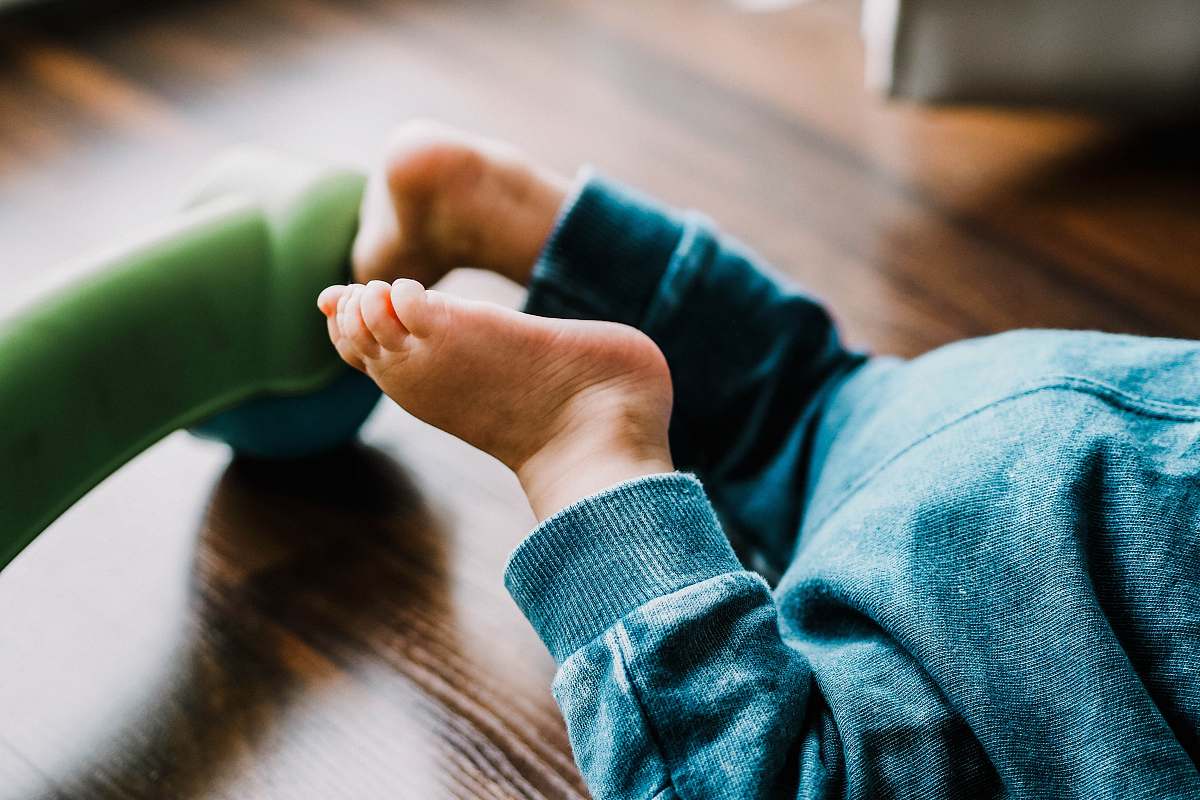 wood baby wearing blue pants hardwood