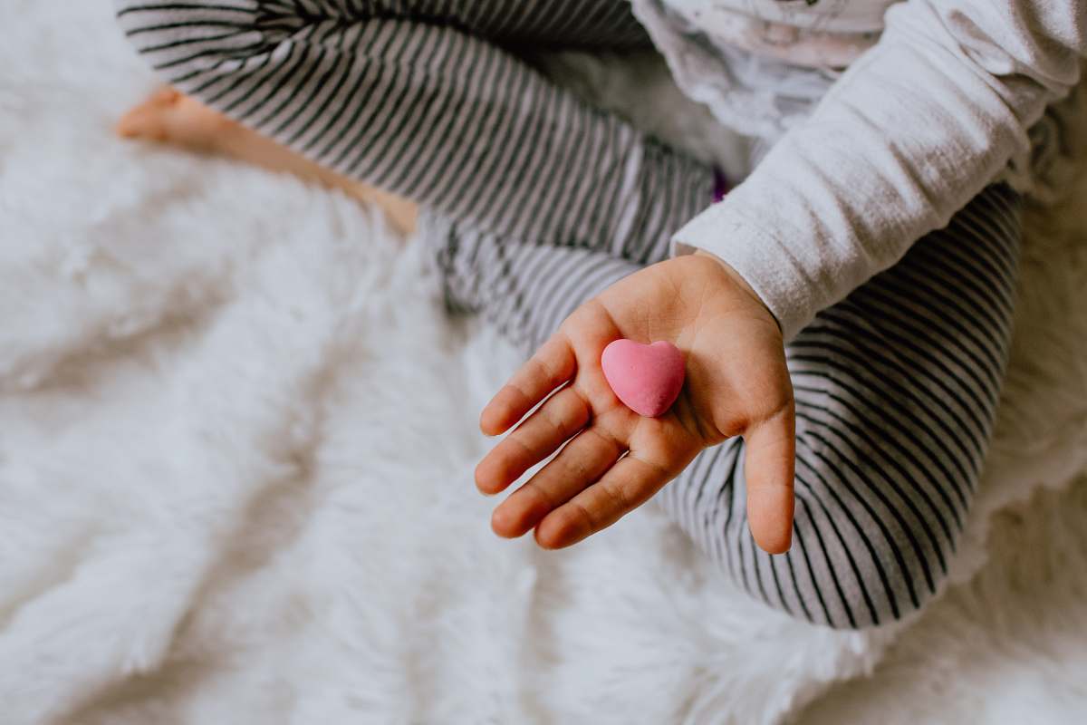 human child holding heart stone person