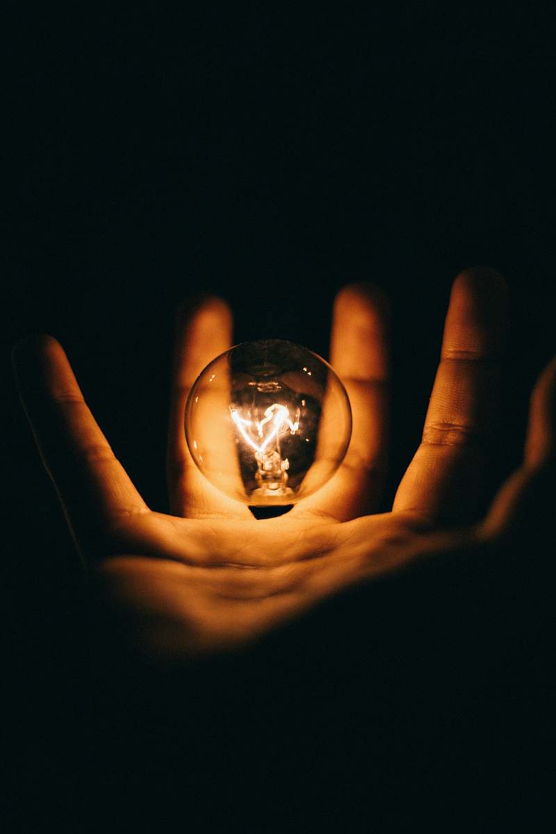 light clear glass bulb on human palm bulb