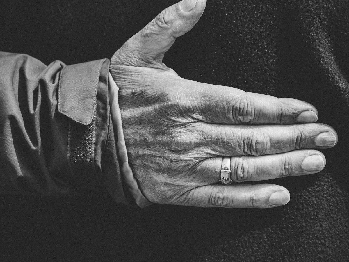 black-and-white close-up photo of person wearing wedding ring grey