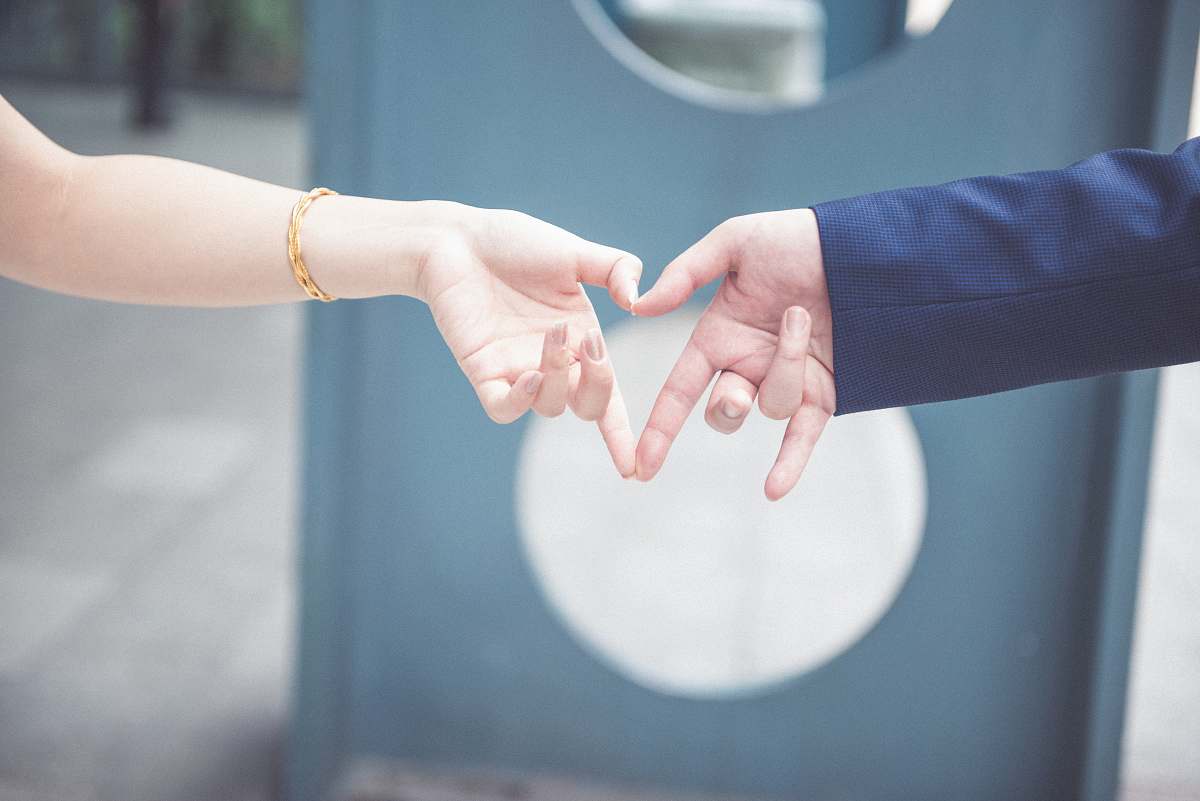 man couple making heart shape with their hands finger