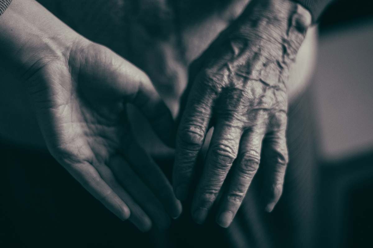 grey grayscale photo of two hands about to hold finger