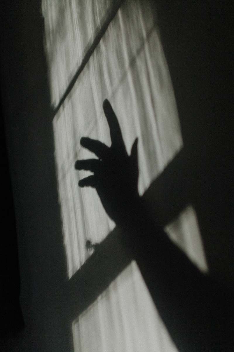 grey hand shadow on glass window finger