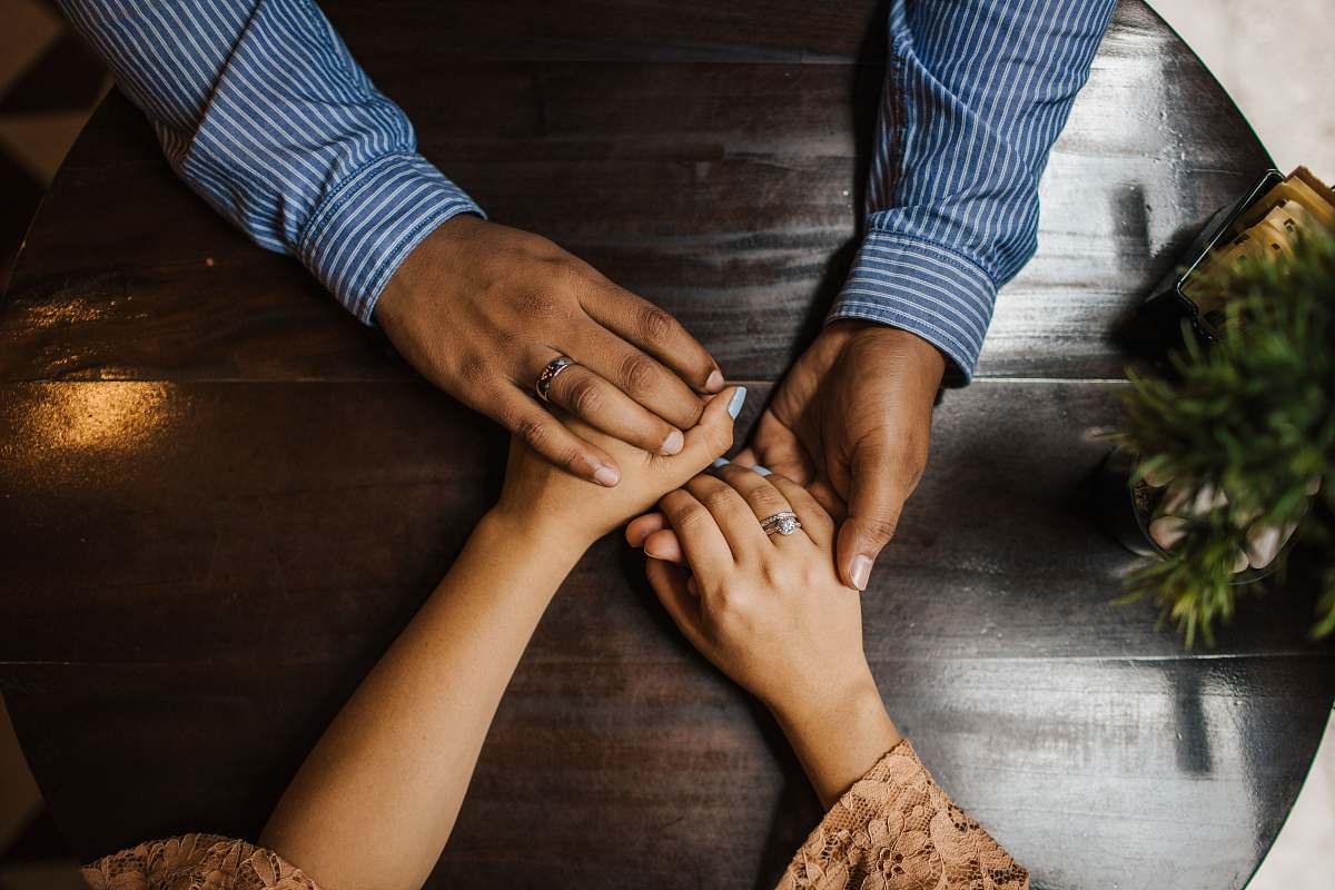 person hands holding on brown wooden table human