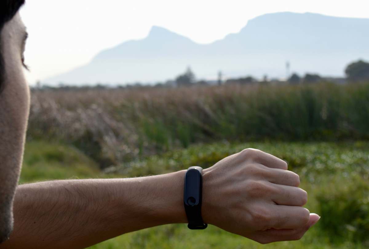 human man looking at black fitness tracker wrist