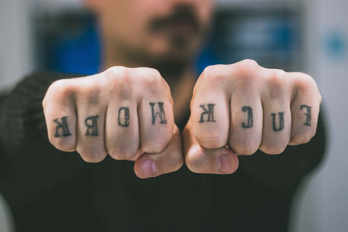 skin man showing his tattoos on hand fist