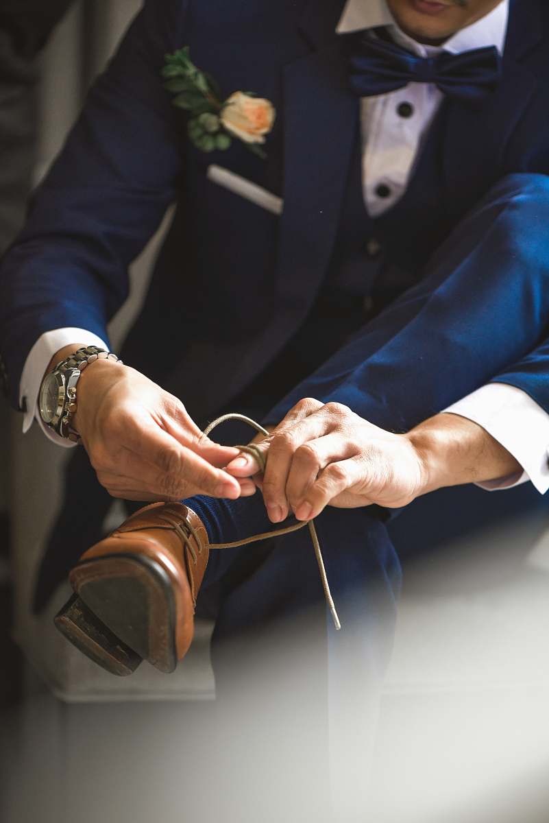 finger man ties his dress shoes accessory