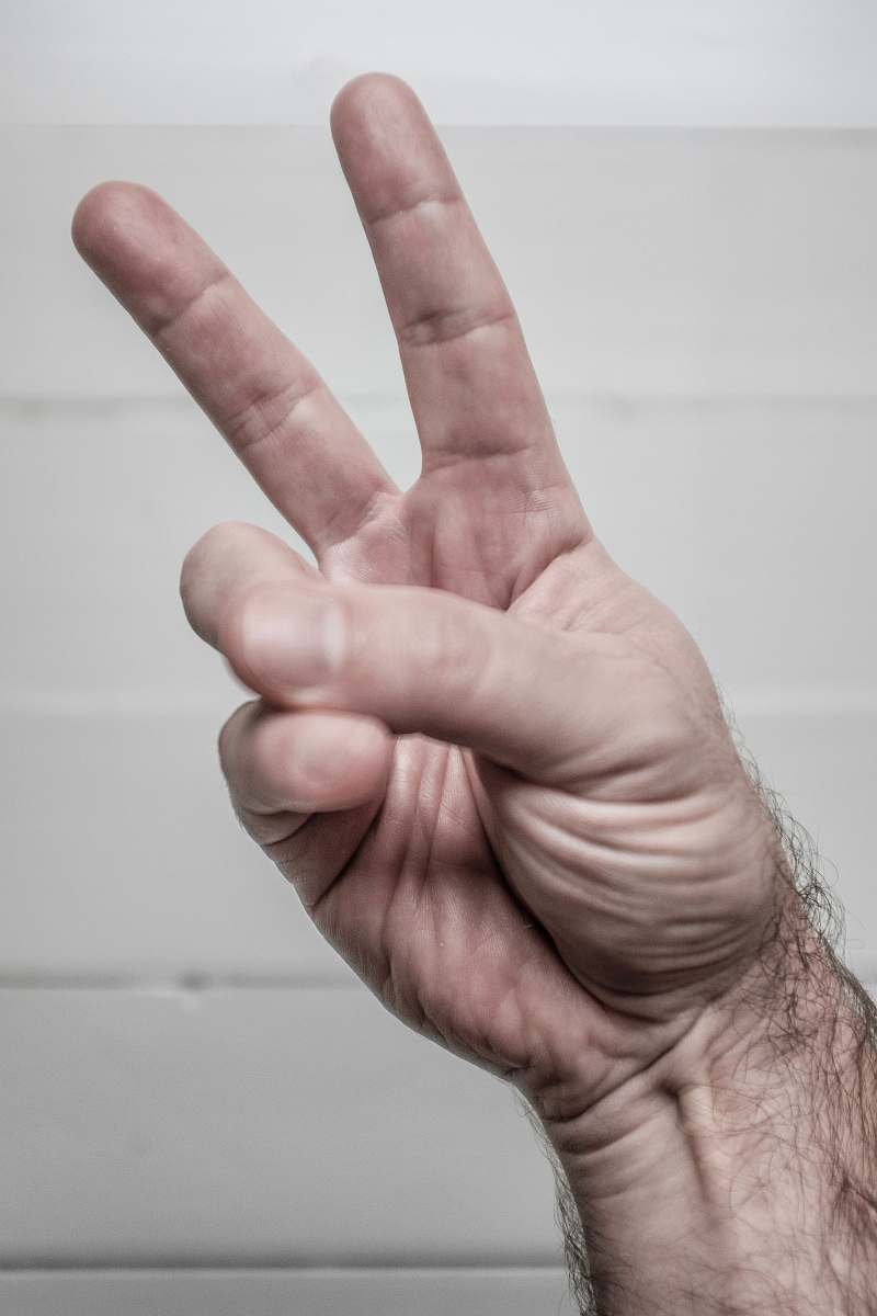 finger person doing hand peace symbol person