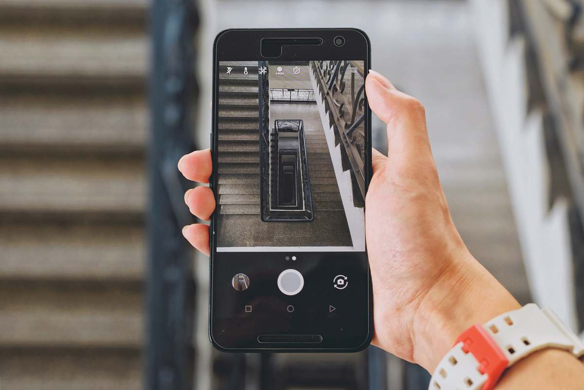 phone person holding Android smartphone displaying camera hold