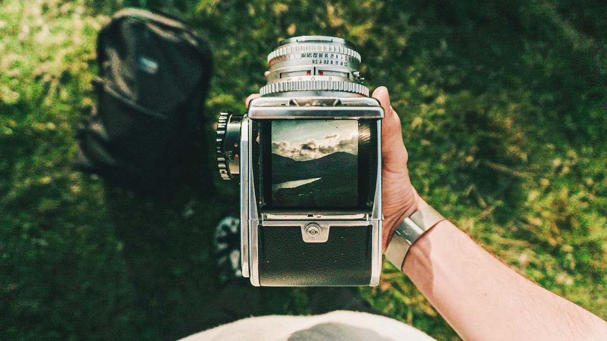 holding person holding black and gray folding camera digital watch