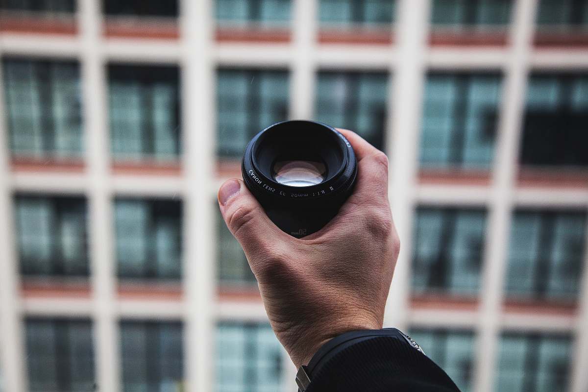 hold person holding black camera zoom lens selective focus photography holding