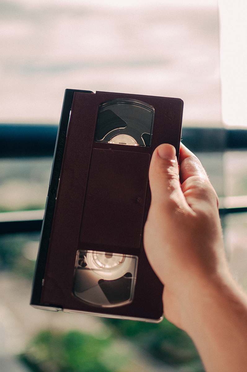 video person holding black VHS tape vintage