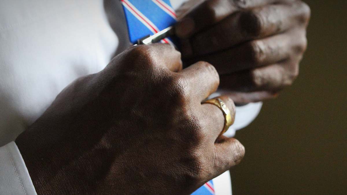 ring person holding blue necktie suit