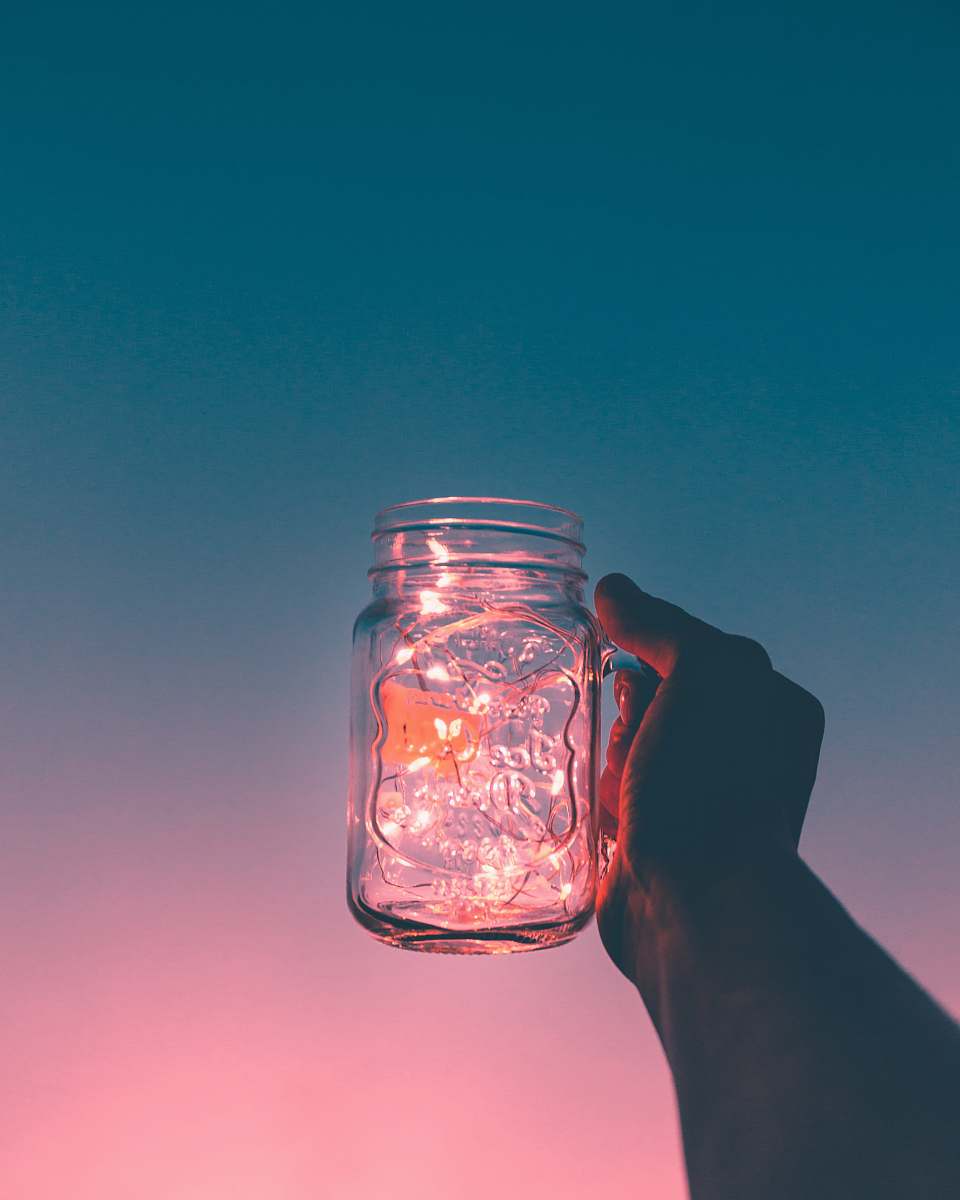 glass person holding clear glass mug jar pink