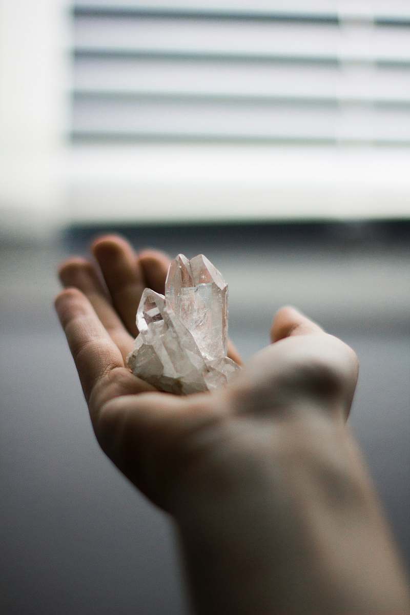 crystal person holding crystal stones cologne