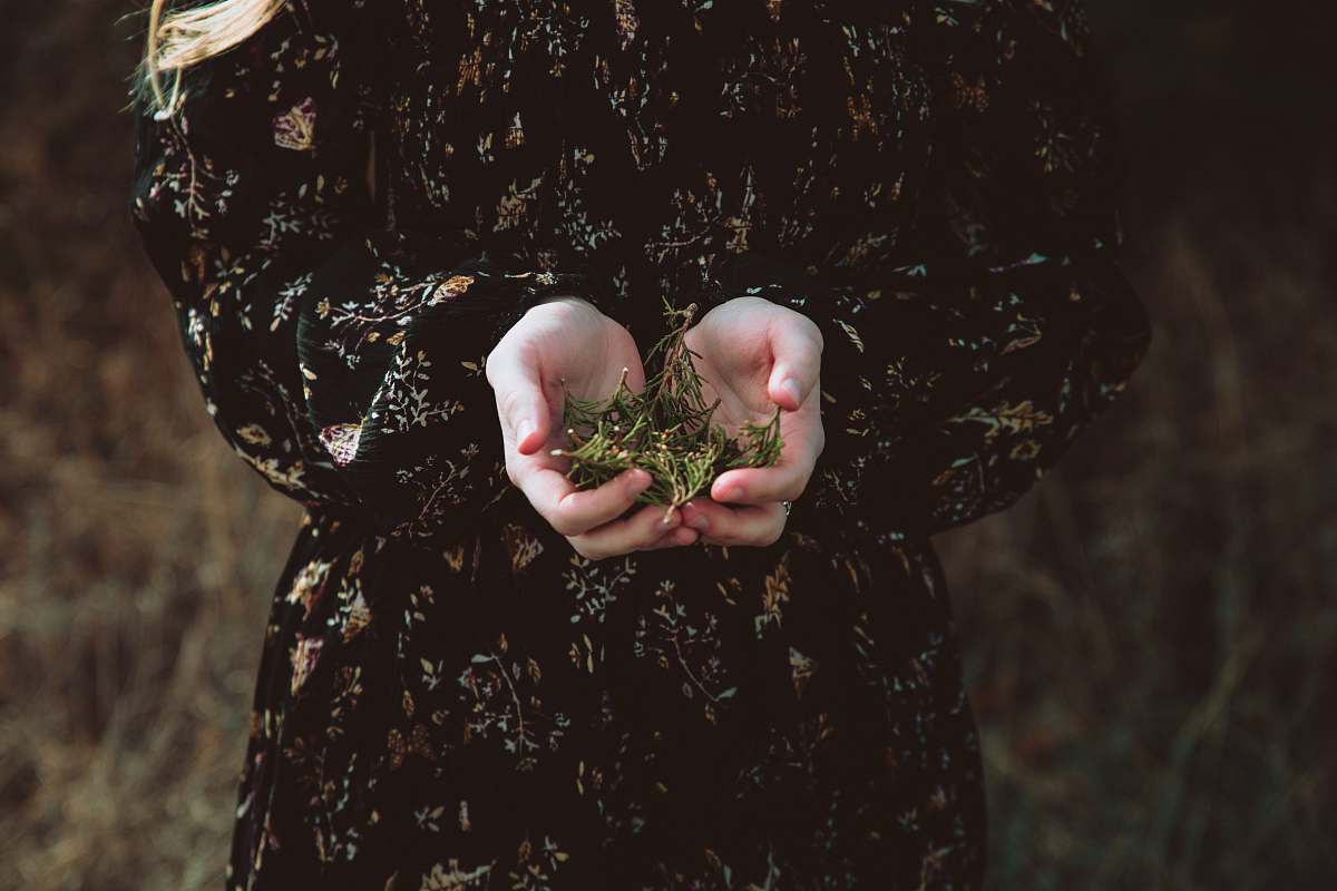 floral person holding green leaves hold