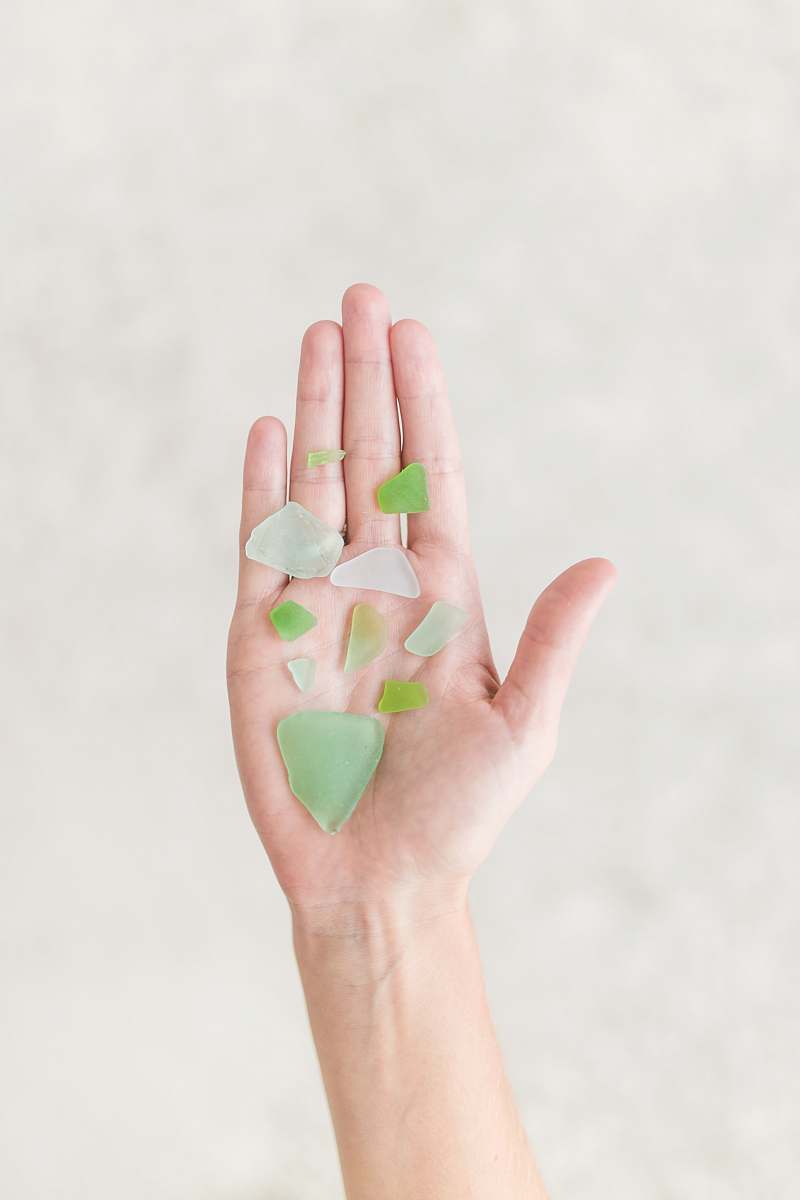 glass person holding green shards sea