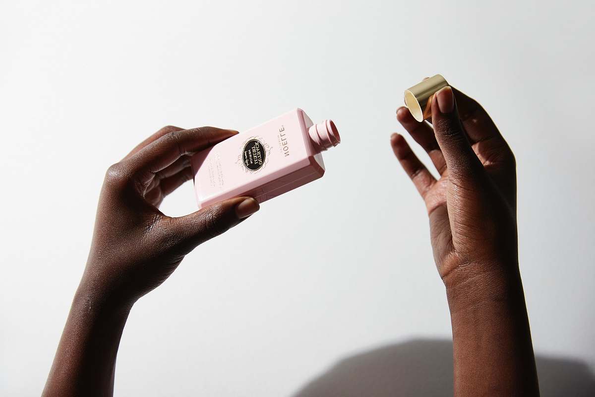 arm person holding makeup bottle cleansing