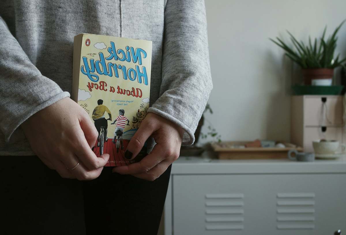book person holding Nick Hornby's About a Boy book plant