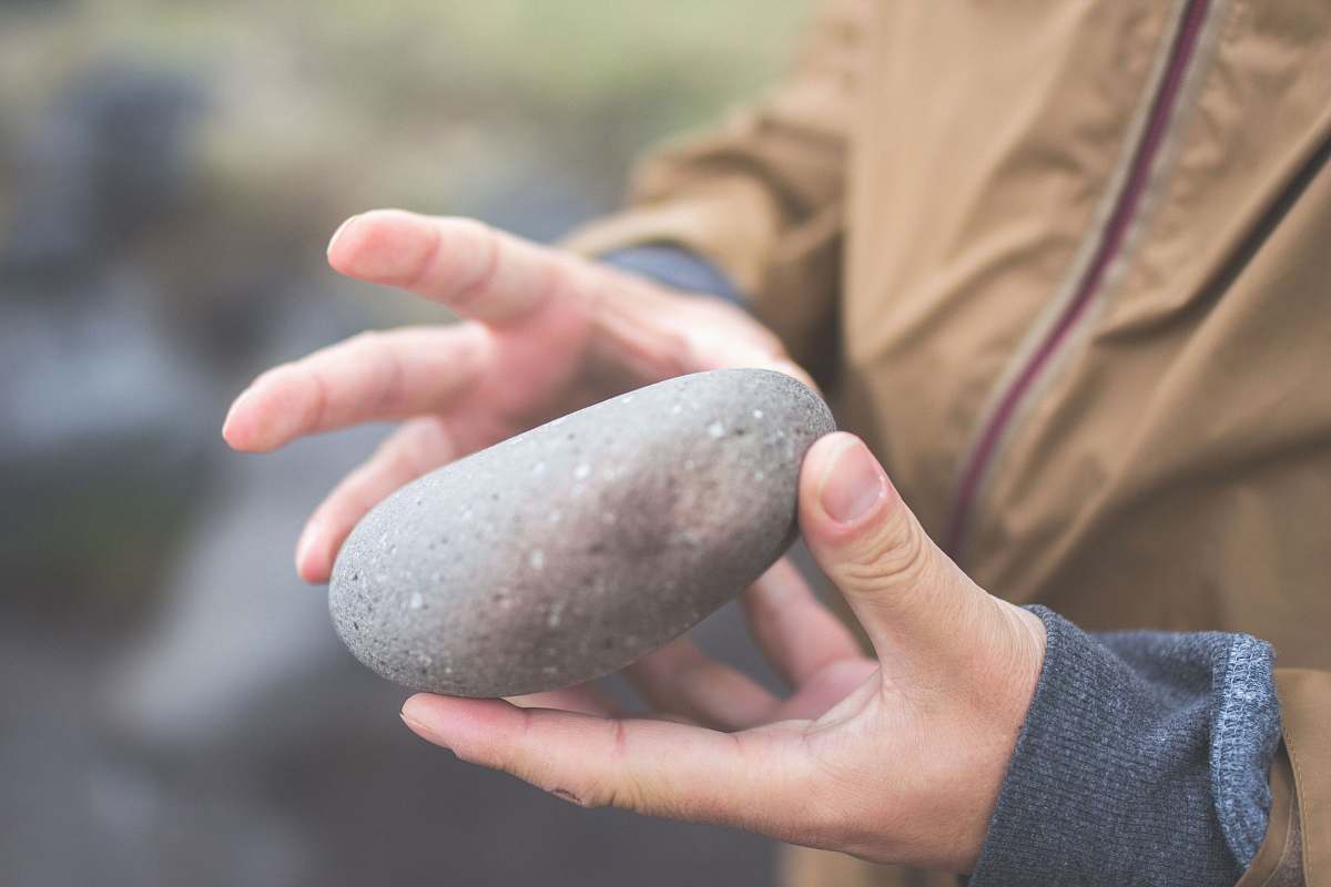 rock person holding river rock stone