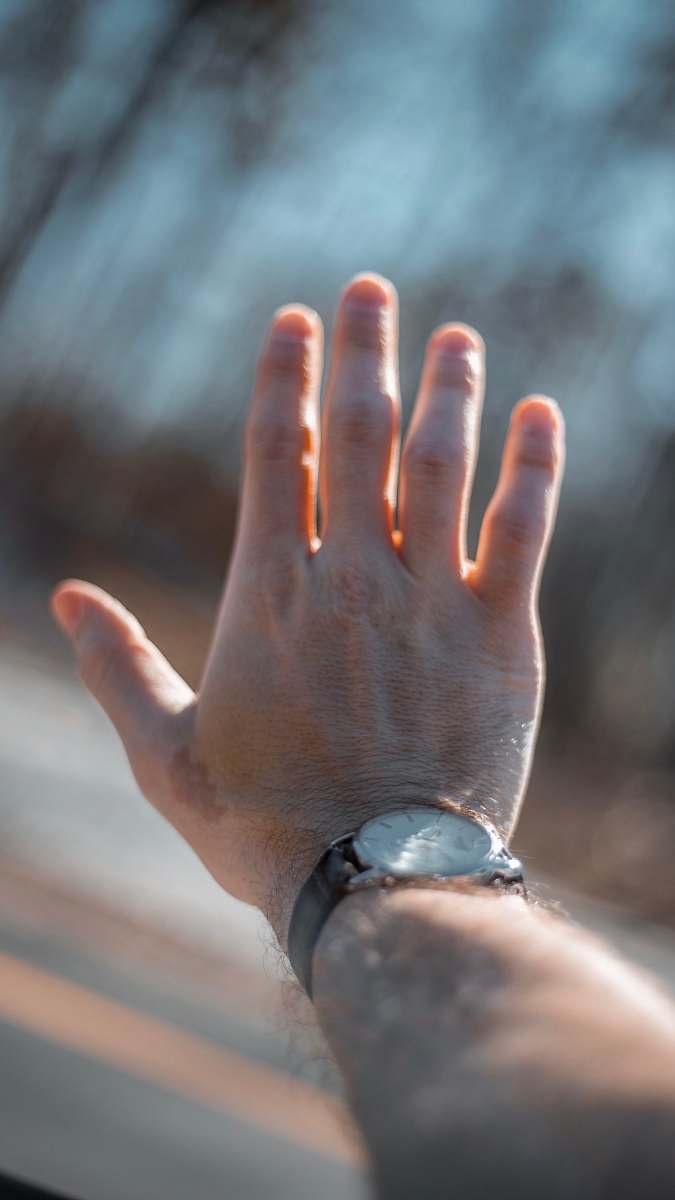richmond person holding silver-colored analog watch grey