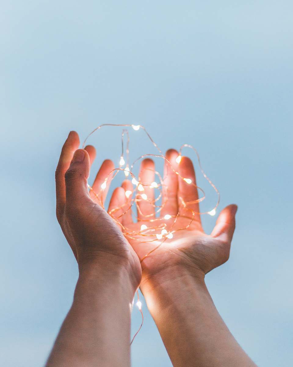 light person holding string lights hands