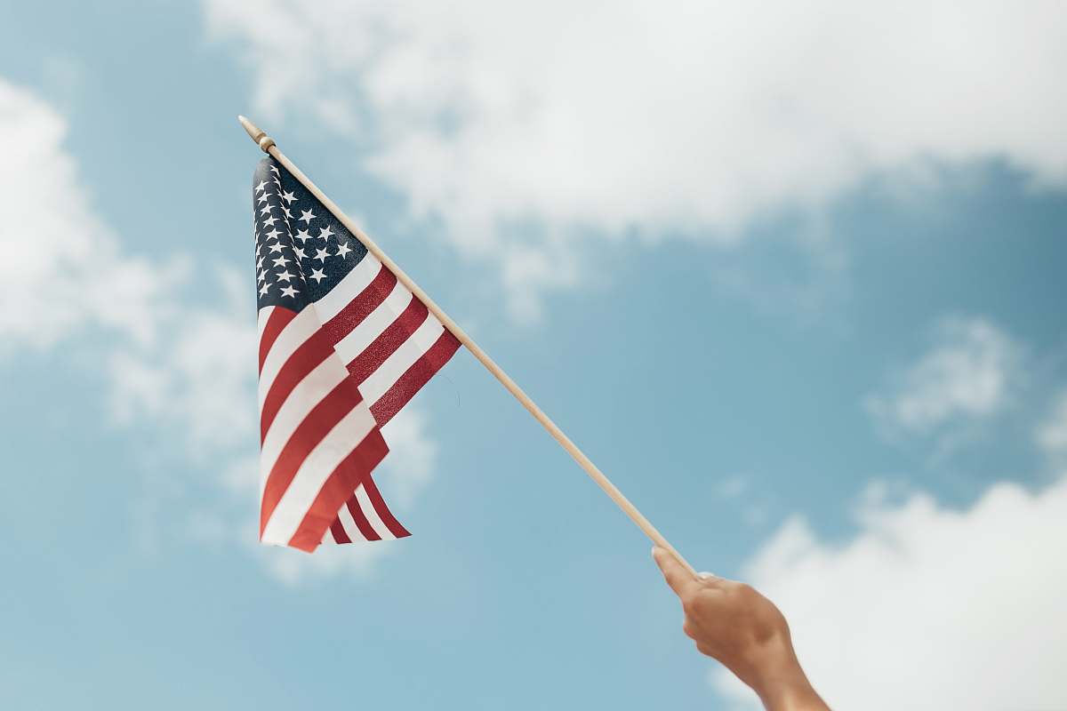 flag person holding U.S.A. flag emblem
