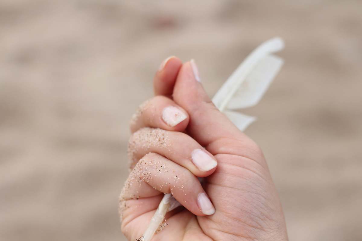 feather person holding white feather minimal