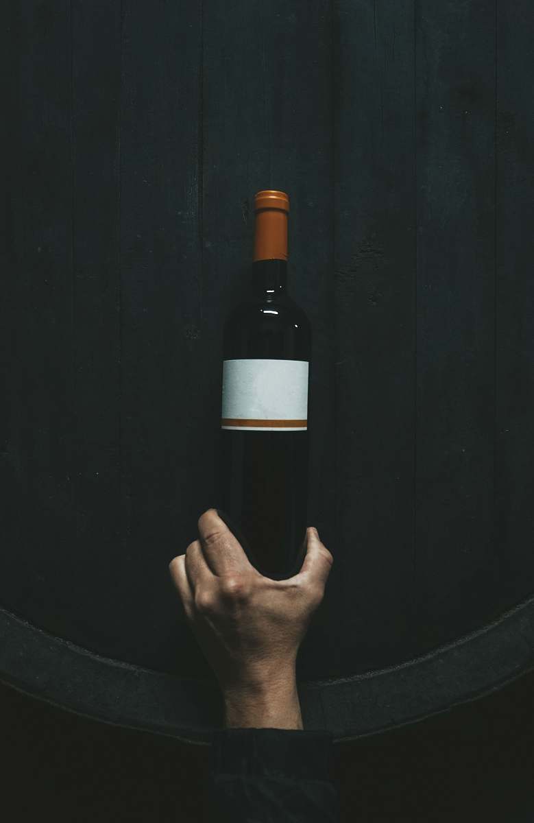 wine person holding white labeled bottle bottle