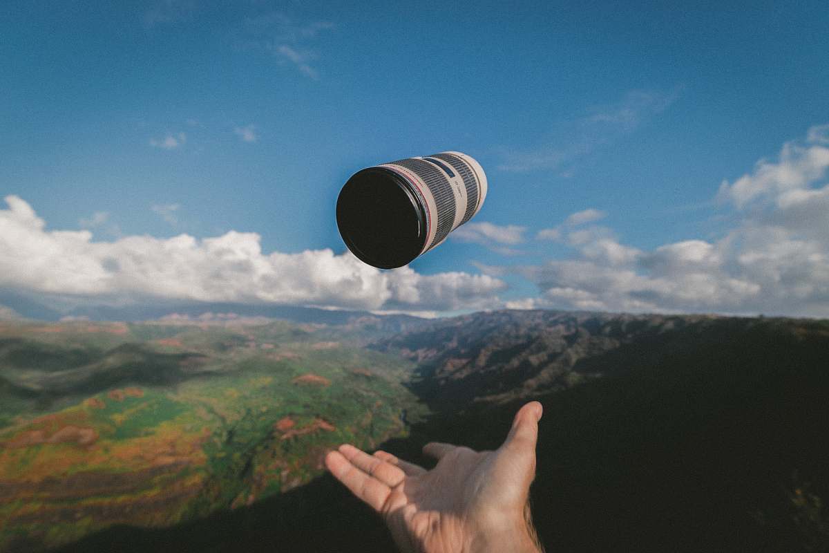 outdoors person throwing black and white Canon lens sky