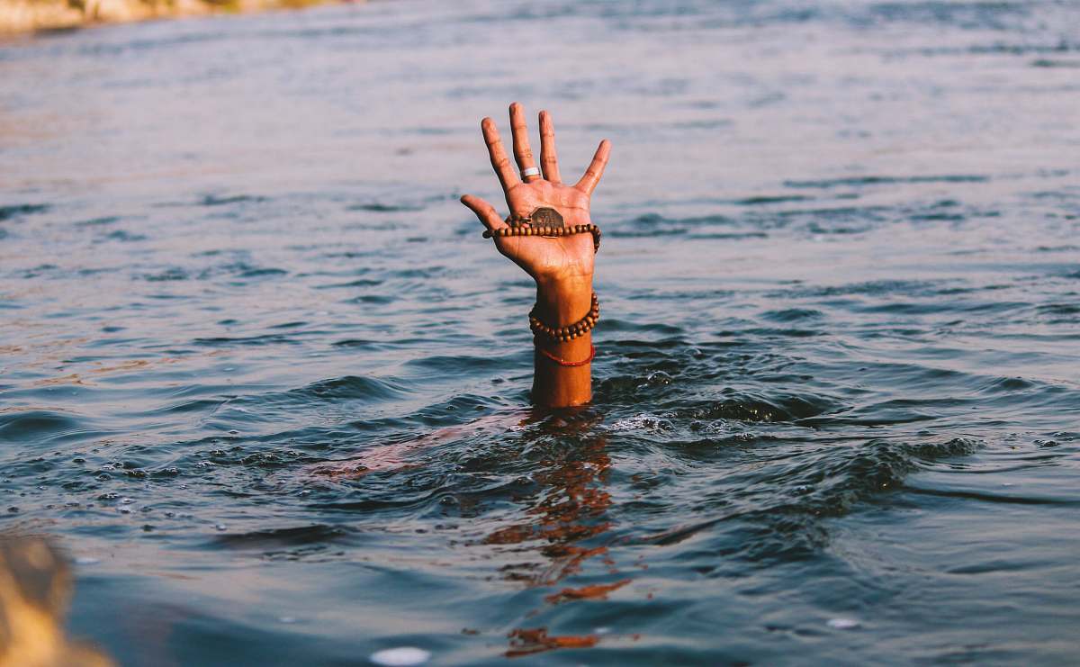 finger person underwater raising right hand outdoors