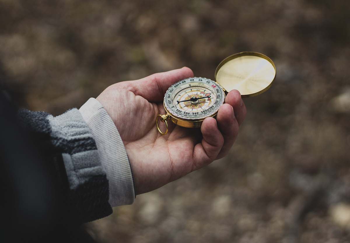 travel person using white and gold compass direction