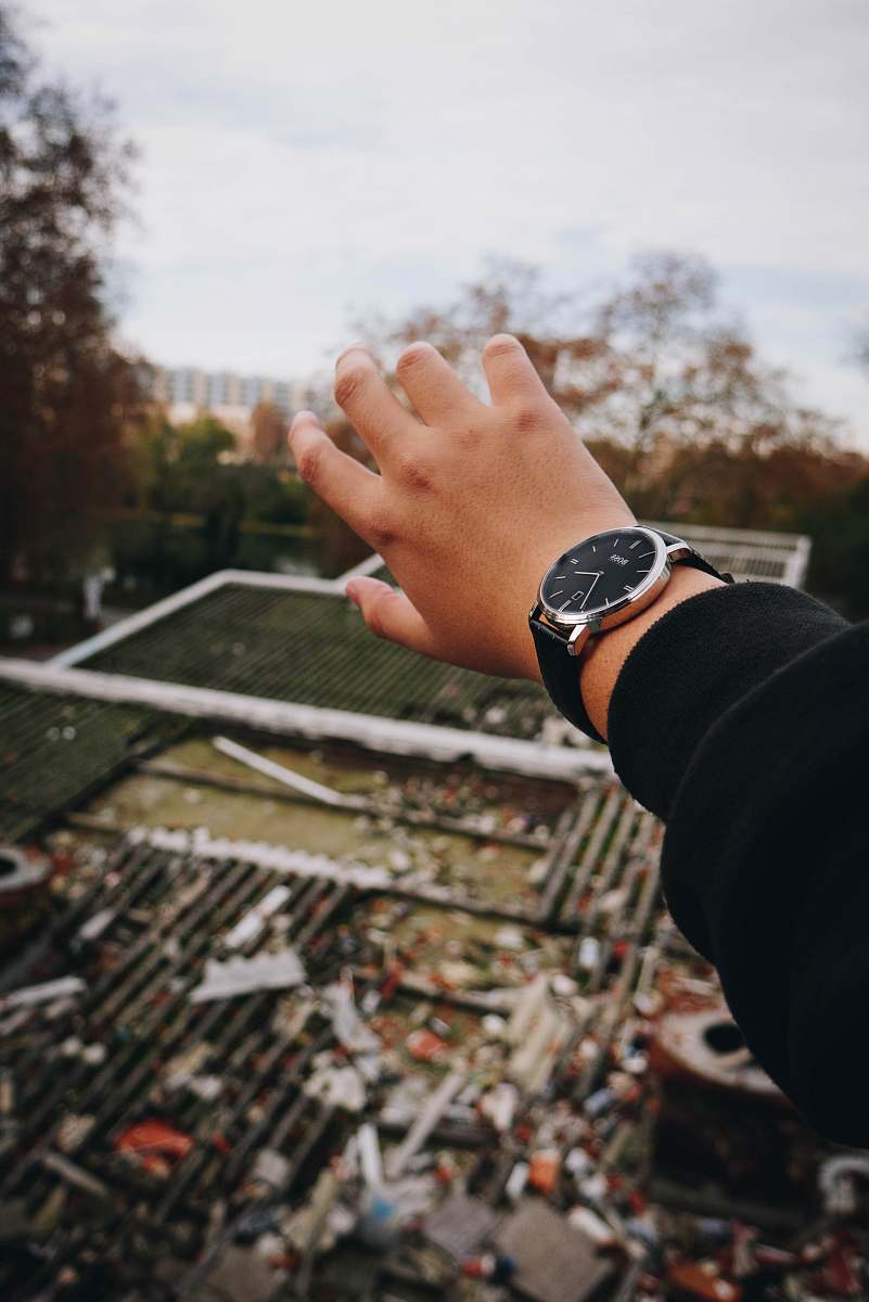 person person wearing black jacket and round silver-colored and black analog watch during daytime human