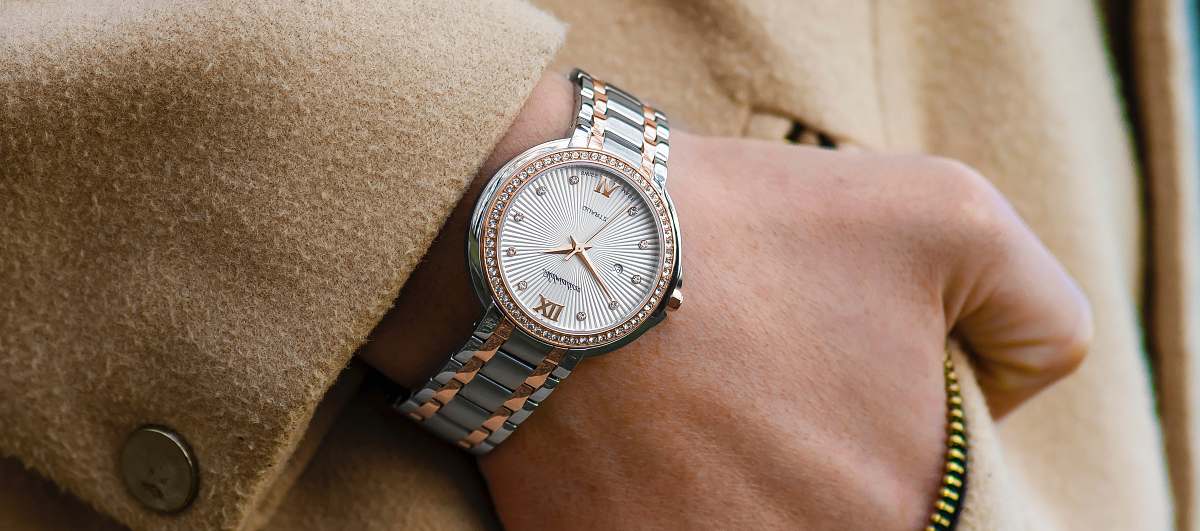 wristwatch person wearing round gold-colored analog watch with link band watch