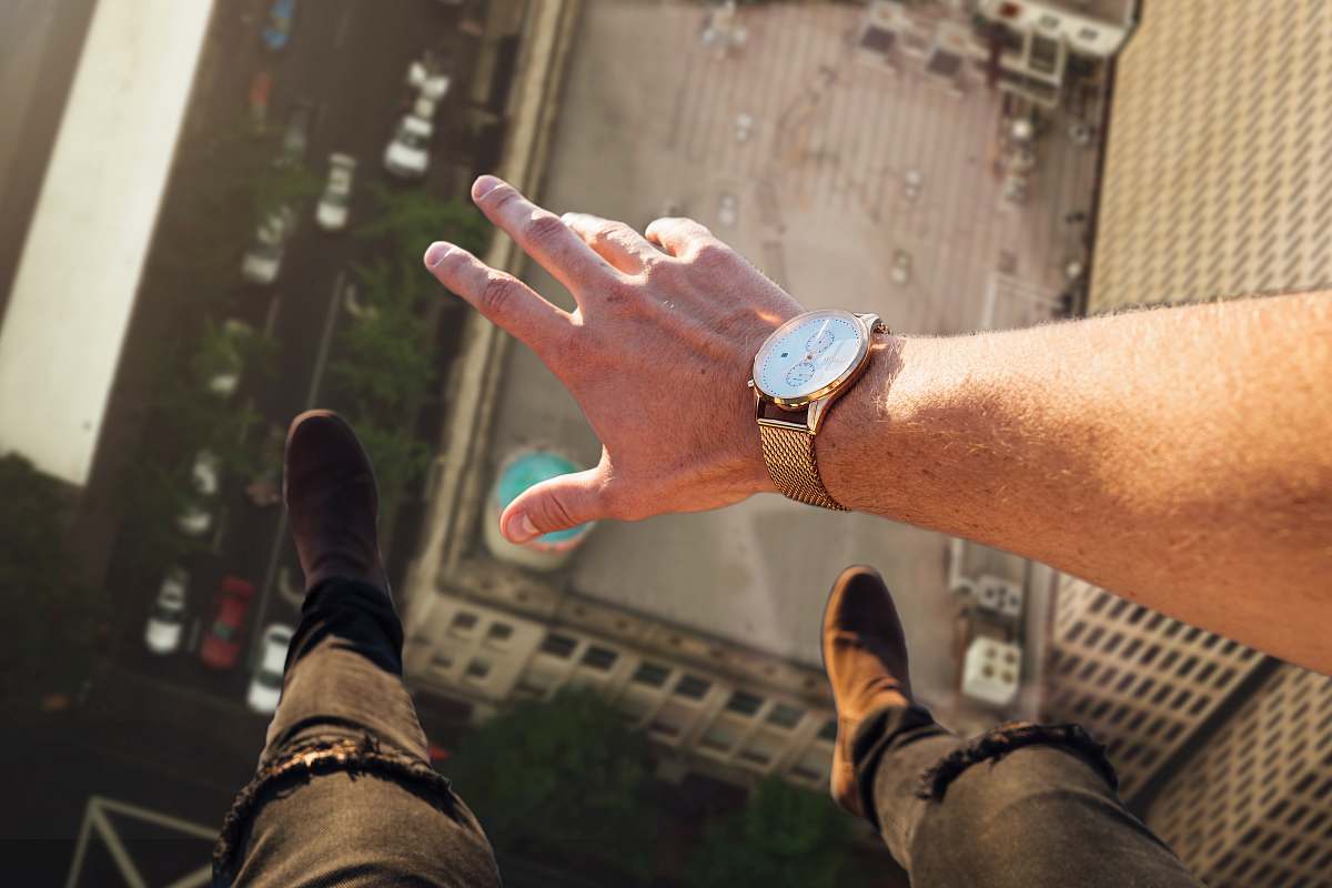 human person wearing round gold-colored watch wristwatch