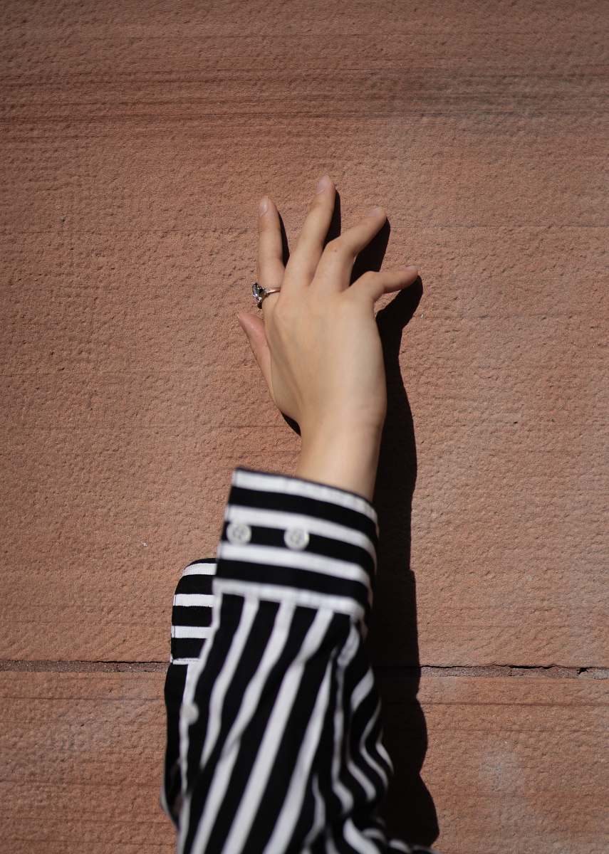 human person wearing white and black striped long-sleeved shirt wrist