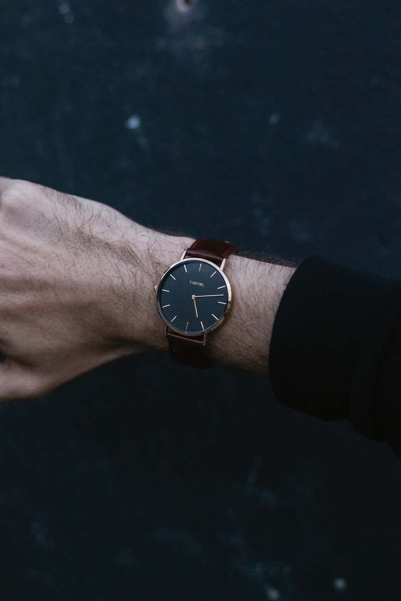 wristwatch person wears analog watch reading 06:47 wrist