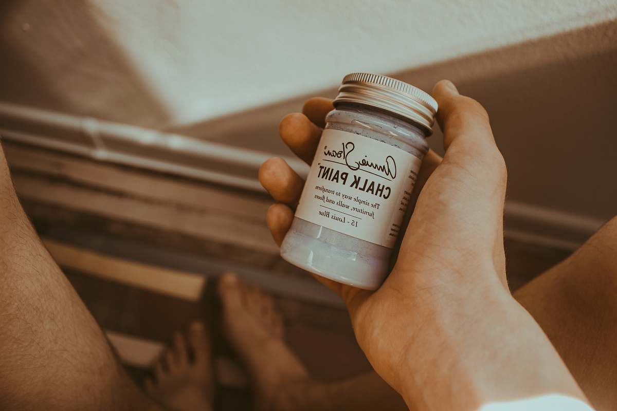 holding person's hand holding Chalk Paint bottle chalk paint