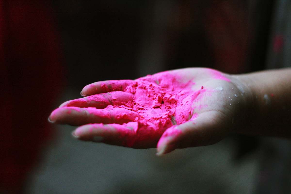 finger pink powder in right human palm pink