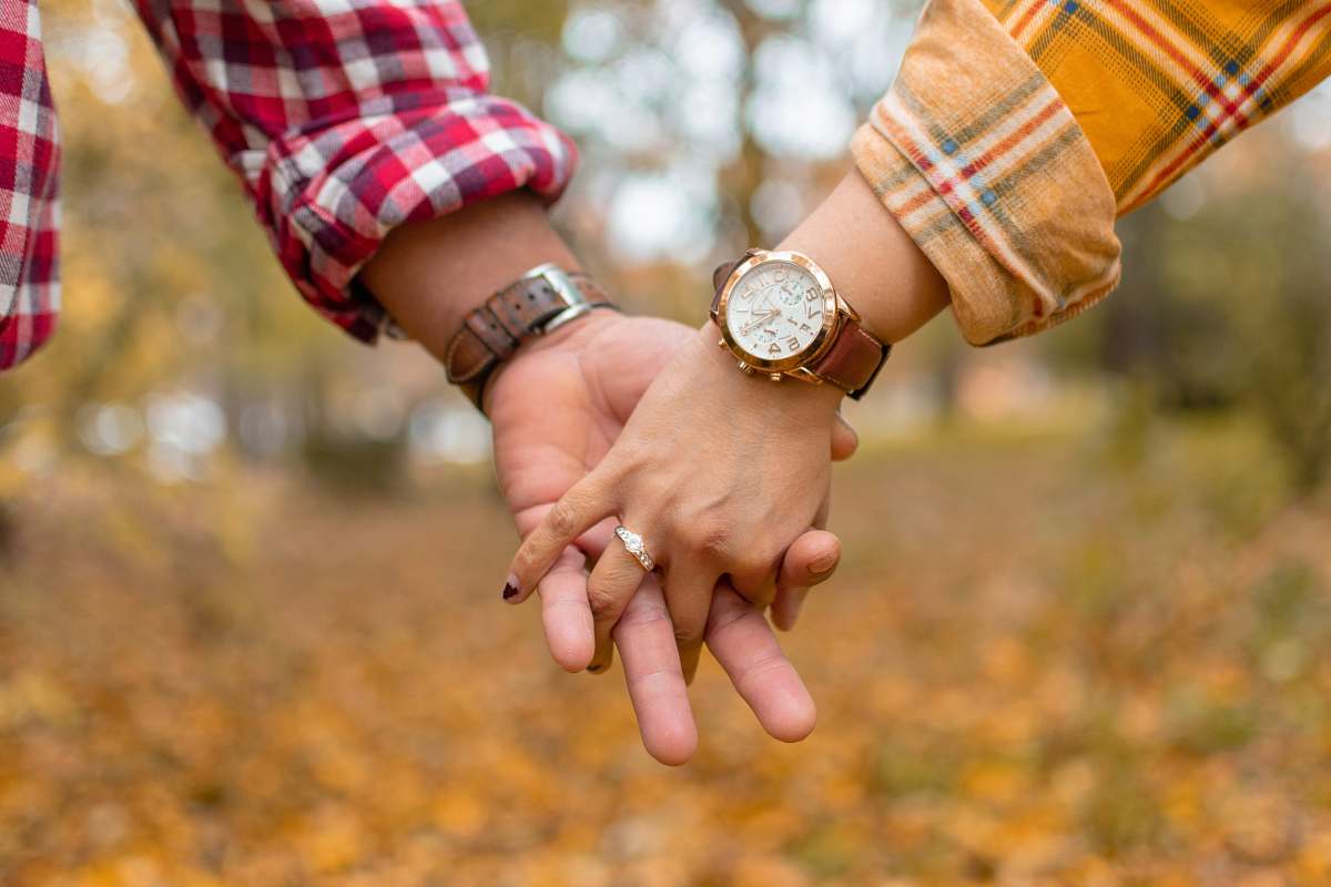 human selective focus photography of man and woman holding hands holding hands