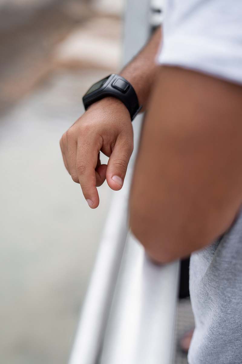 human selective focus photography of man wearing black smartwatch wristwatch