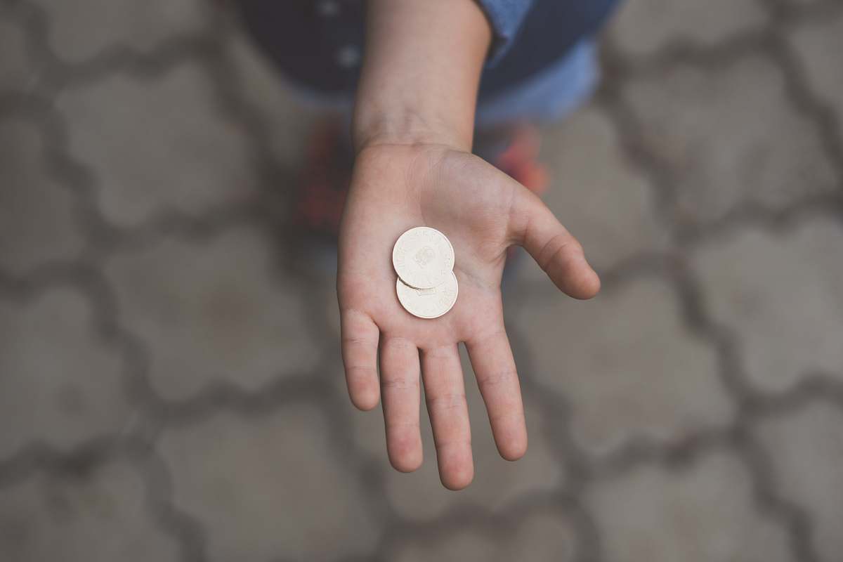 coin selective focus photography of person's palm with two coins money