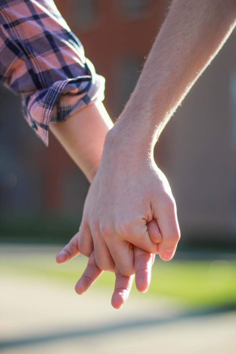 human selective focus photography of two people holding hands together holding hands