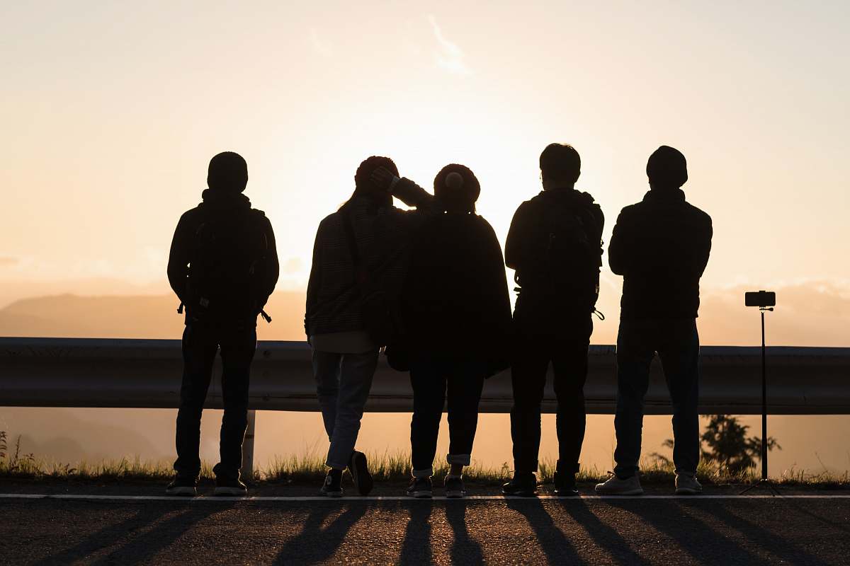 human silhouette photography of people standing near road barricade person