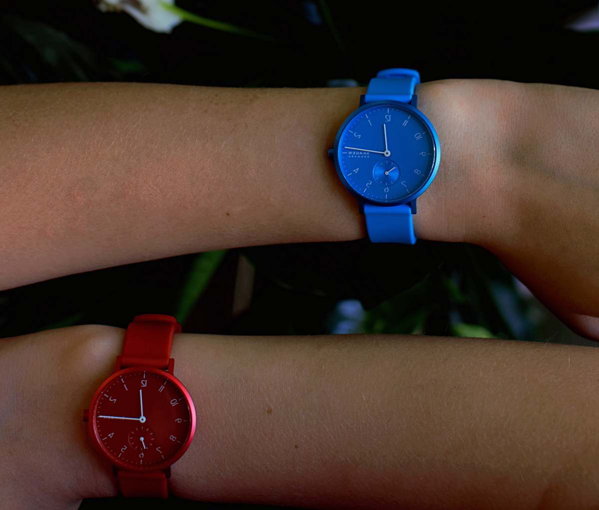 wrist two person wearing blue and red analog watches wristwatch