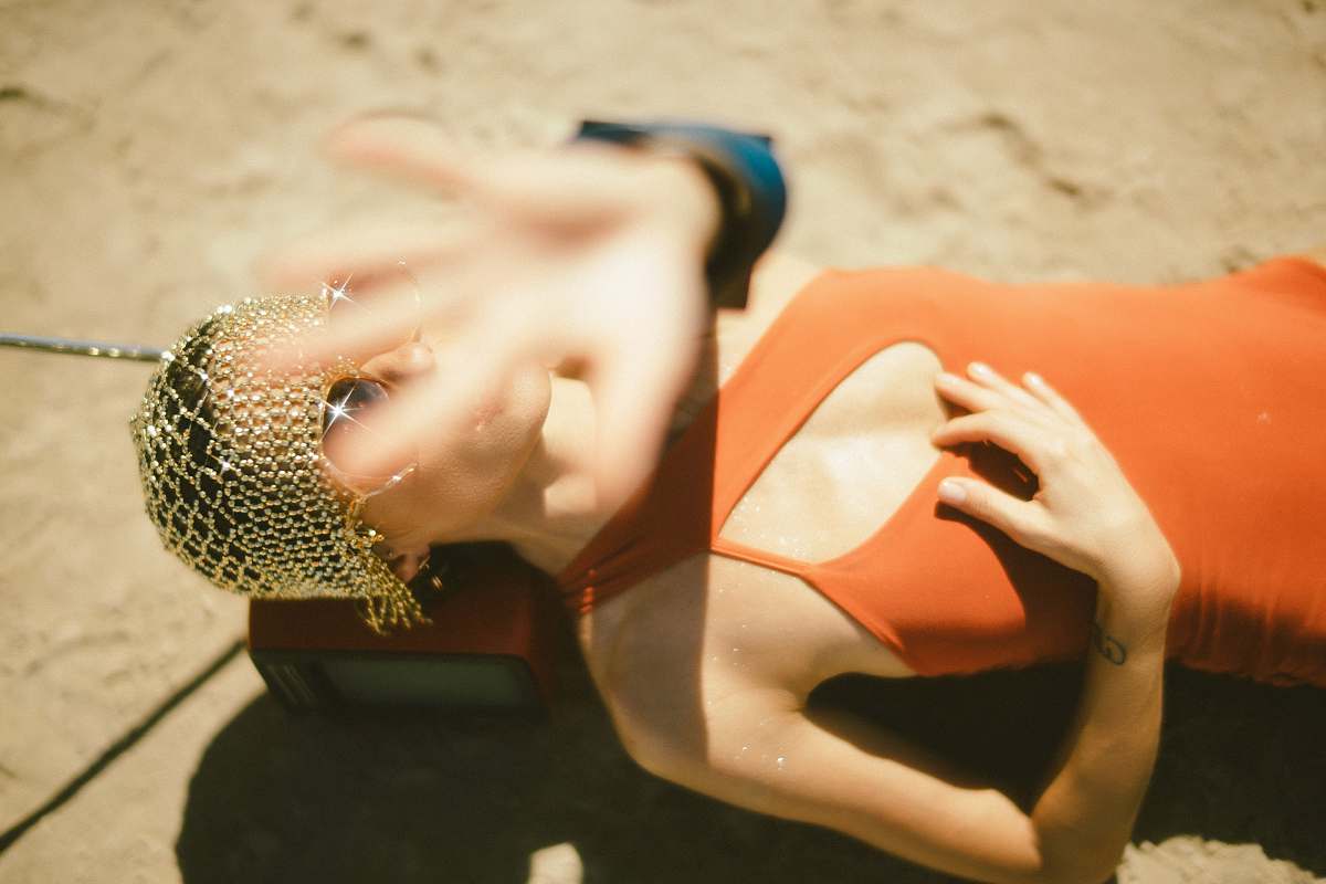 human woman in orange dress lying on ground finger