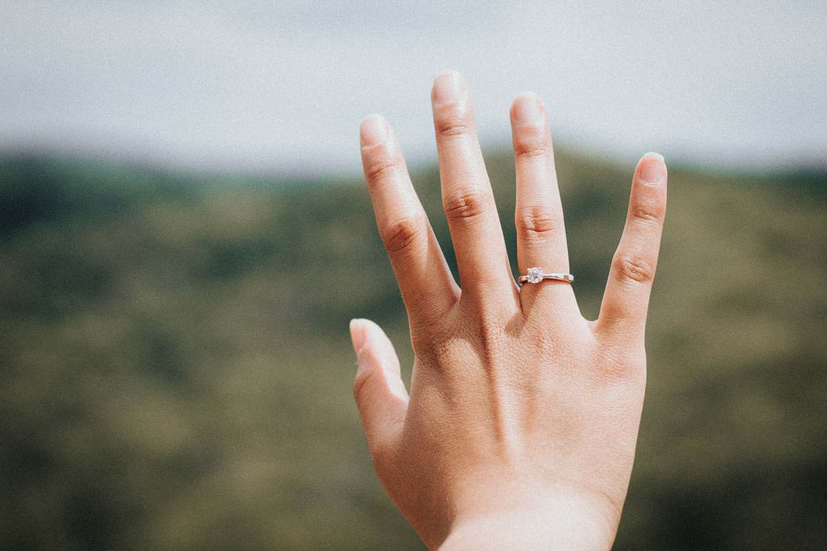 finger woman showing her silver-colored ring nail