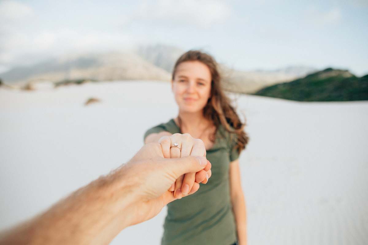 human woman wearing green top holding hand person