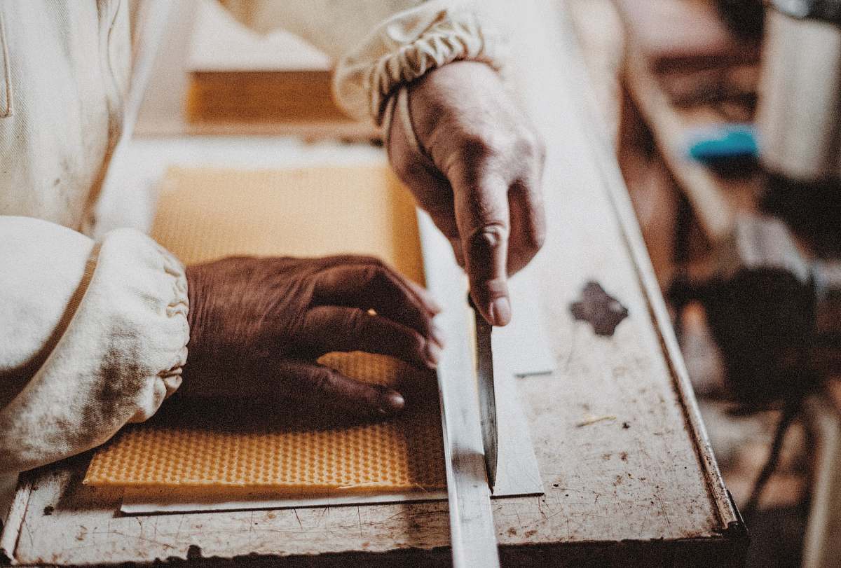 work person holding chisel while carving wood knife